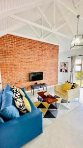 德班Stylish Loft Style Apartment的客厅设有蓝色的沙发和砖墙