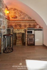 CaccamoLa Casa Dei Cavalieri的厨房设有拱形门,配有炉灶和冰箱