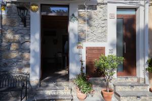 CaccamoLa Casa Dei Cavalieri的石头房子,有门和两盆植物