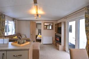 East MerseaRohannah static Caravan Fantastic Family and Friends Holiday的厨房以及带沙发和桌子的客厅。