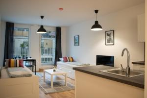 维也纳Flat2go modern apartments - Harmony of city and nature的厨房以及带沙发的起居室。