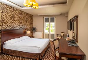 奥尔什丁韦林斯基酒店的酒店客房配有一张床、一张书桌和一台电视。
