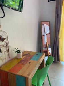 普拉亚弗拉明戈Surfside Mar Y Posa的配有木桌和绿色椅子的客房