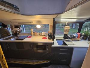 NortonMooview- the charming double decker bus的厨房位于走廊,设有水槽和炉灶。