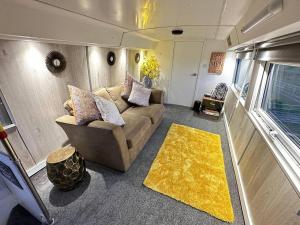 NortonMooview- the charming double decker bus的带沙发和黄色地毯的客厅