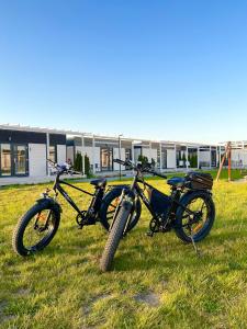 萨比诺瓦Resto domki letniskowe的两辆摩托车停在大楼前的草上
