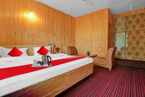 斯利那加OYO Hotel Jay Palace的酒店客房配有一张带红色枕头的大床