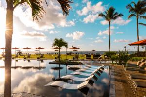 卡帕阿Sheraton Kauai Coconut Beach Resort的棕榈树和海洋度假村的游泳池