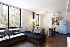 巴塞罗那Apartment Vila Olímpica Barcelona next to beach & garden的带沙发、桌子和冰箱的客厅