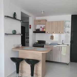 辛塞莱霍Apartamento Tranquilo para Descansar的厨房配有柜台和2张黑色凳子