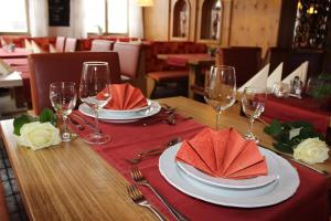 罗斯豪普滕陶尔米纳比萨餐厅旅馆的一张桌子,上面放着红餐巾和酒杯
