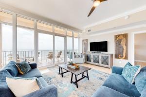 格尔夫海岸Phoenix Gulf Shores的客厅配有蓝色的沙发和电视