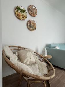 米尔芳提斯城Casa dos Avós的柳条椅,墙上有枕头和盘子