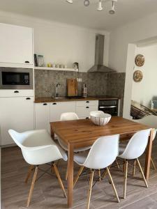 米尔芳提斯城Casa dos Avós的厨房配有木桌和白色椅子