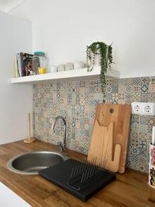 米尔芳提斯城Casa dos Avós的厨房柜台设有水槽和切板