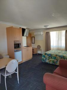 达博四季汽车旅馆的酒店客房设有一张床铺、一张桌子和一间厨房。