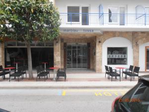 滨海托萨多萨德马尔酒店的一组桌子和椅子,位于大楼前