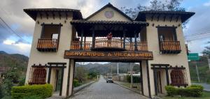 比尔卡班巴In the heart of Vilcabamba. Residence don Tuquito.的带阳台的建筑,上面有标志