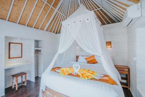 蓝梦岛Paluh Beach Huts的一间卧室配有一张带天蓬的白色床