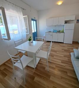 伊格拉恩Seaside holiday house Igrane, Makarska - 21577的一间带桌椅的客厅和一间厨房