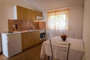 拉布Apartments by the sea Supetarska Draga - Gornja, Rab - 21380的厨房配有桌子和白色冰箱。