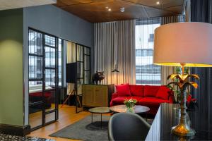 赫尔辛基Hotel U14, Autograph Collection的客厅配有红色的沙发和桌子