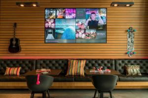 美因河畔法兰克福慕奇夕法兰克福机场酒店的一间配有沙发和墙上电视的餐厅