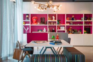 美因河畔法兰克福慕奇夕法兰克福机场酒店的一间带桌子和粉红色墙壁的用餐室