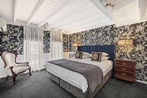 奥林达磨坊阁楼精品酒店的一间卧室配有一张床和一把椅子