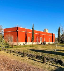 梅塞德斯Casa en Haras Bettina的一座红色的大建筑,前面有树木