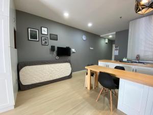金宝A Modern & Homely Studio with Pool and Gym的一间卧室配有一张床、一张桌子和一张桌子