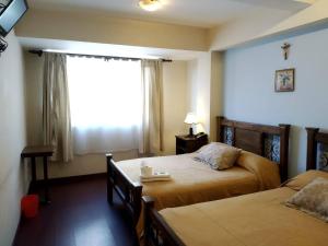 科恰班巴Hotel Maison Fiori Prado的酒店客房设有两张床和窗户。