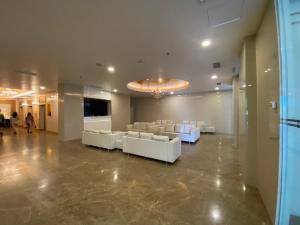 金宝A Modern & Homely Studio with Pool and Gym的一个带白色沙发和电视的大型大堂