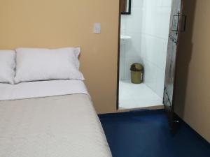 莱蒂西亚Hotel Gavas Amazonas的一间带床和镜子的卧室以及一间浴室