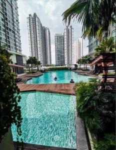 普特拉贾亚Conezion Residence Putrajaya WiFi Netflix的一座位于城市的游泳池,有高大的建筑