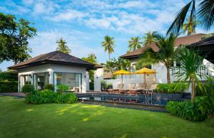 班奥南矛The ShellSea Krabi I Luxury Beach Front Resort & Pool Villa的一个带椅子的庭院和游泳池的房子