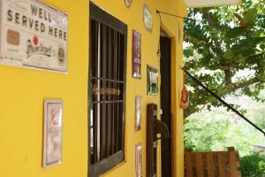 坎佩切Habitacion Roja / Casa del Café的黄色房子的一侧有海报