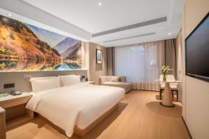 成都成都太古里IFS国金中心亚朵X酒店的卧室配有一张白色大床和电视。