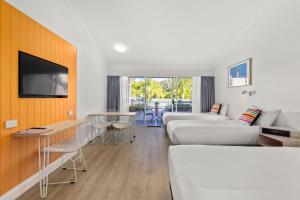 楠巴卡黑兹The Cubana Resort Nambucca Heads的酒店客房设有两张床和一台平面电视。