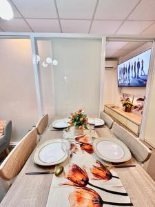 卡加盐德奥罗3 Smart Condominium in Cagayan de Oro City的餐桌,配有盘子和酒杯