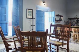 坎佩切Habitacion Azul / Casa del Café的一间设有蓝色门和桌椅的用餐室