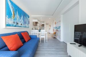 胡安莱潘Appartement 6 couchages dans résidence avec piscine的客厅配有蓝色的沙发和电视