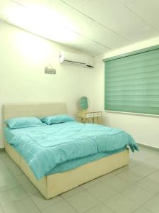 亚依淡AAA Homestay Georgetown Penang的一间卧室配有一张带蓝色床单的床和一扇窗户。