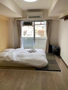 广岛La Foret Fujimi的一间卧室设有一张床和一个大窗户