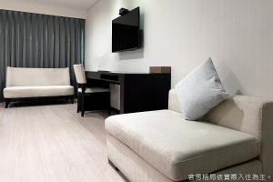 高雄Talmud Hotel Kaohsiung LoveRiver的带沙发和书桌的客厅