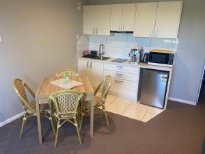 科夫斯港Central Oasis的厨房配有桌椅和微波炉。