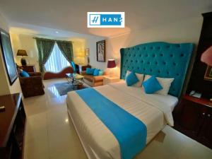 胡志明市HANZ Vuon Saigon Hotel & Spa的一间带蓝色床的卧室和一间客厅