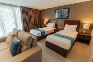 马比尼Solitude Acacia Resort的酒店客房,设有两张床和一张沙发