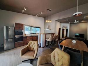 格兰贝伊Tropical 3-bedrooms Coastal Residence Creolia的厨房以及带桌椅的起居室。