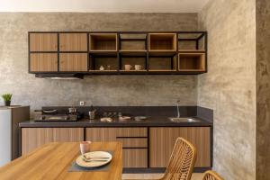 塞米亚克Cove Kanaya的厨房配有木制橱柜和木桌及椅子